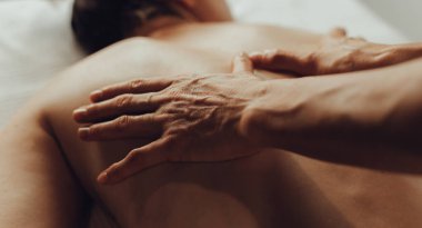 Masaj masasında yatan genç bir kadının omuzlarına masaj yapan kadın masörlerin elleri. Fizik tedavi konsepti, boyun basınç noktası..