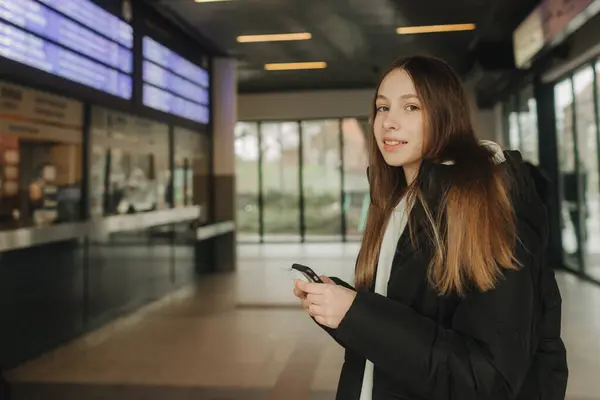 スマートフォンマップ ソーシャルメディアチェックイン またはチケット予約を使用して電車の駅で観光十代の少女 モダンな旅行アプリテクノロジー 孤独な旅行者 冬の休暇鉄道アドベンチャーコンセプト — ストック写真