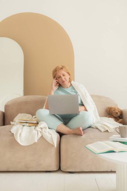 Gülümseyen son sınıf öğrencisi kadın evde dinleniyor dizüstü bilgisayar kullanıyor video veya film izliyor teknolojiden, boş zamanlardan, emeklilik yaşam tarzından keyif alıyor..