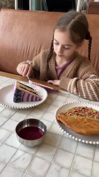 Vakker Jente Som Bruker Mobiltelefon Mens Spiser Frokost Søt Pre videoklipp