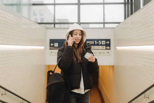 スマートフォンマップ ソーシャルメディアチェックイン またはチケット予約を使用して電車の駅で観光十代の少女 モダンな旅行アプリテクノロジー 孤独な旅行者 冬の休暇鉄道アドベンチャーコンセプト ロイヤリティフリーのストック写真