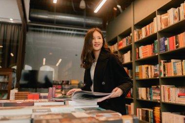 Güzel genç nesil Z Koreli kız kitapçıda kitap seçiyor. Eğitim eğitimi konsepti. Bir serinin parçası.