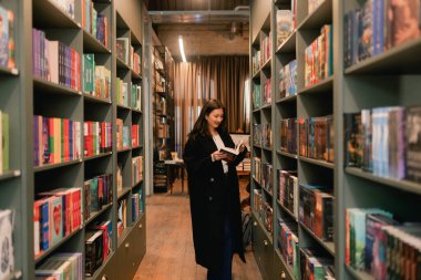 Güzel genç nesil Z Koreli kız kitapçıda kitap seçiyor. Eğitim eğitimi konsepti. Bir serinin parçası.