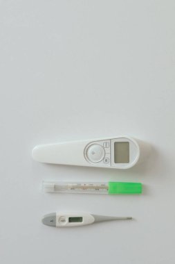 Işık arkaplanındaki insan vücut ısısını ölçmek için cıva termometre, kızılötesi ve elektronik termometre bebek termometresi karşılaştırması. Termometre türleri. Boşluğu kopyala