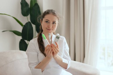 Yakın plan kadın GPS doktoru insan vücut ısısını ölçmek için farklı tipte termometreler tutuyor. Civa, kızılötesi, elektronik. Tıp ve sağlık hizmetleri kavramı. Bir serinin parçası.