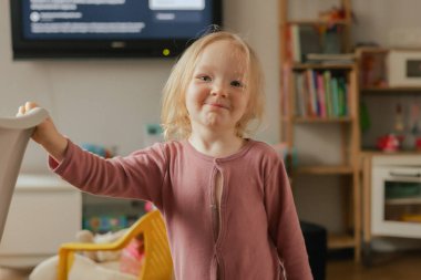 Oyun odasında oyuncaklarla oynayan mutlu bebek portresi. Oyun odasında iki yaşında sevimli bir kız. Üretim alfa kavramı.