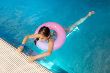 Yüzme havuzunda yüzdükten sonra küçük yüzücü kızın yakın plan portresi. Küçük kız suda boğulmaktan korkuyor. Uzayı kopyala Çocuk güvenliği kavramı havuz suyunun yanında..