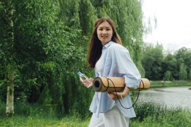 Yoga yaptığı için yoga minderli Koreli kız parkta meditasyon yapacak bir yer arıyor. Doğayla bütünlük ve kendine yeten konsept. Dizinin bir parçası.