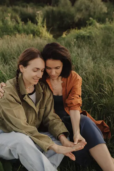 stock image Two happy young Caucasian women enjoying vacation in the forest. Cheerful beautiful girls of generation z pose for photo with mobile phone. Strong female friendship. Part of the series.