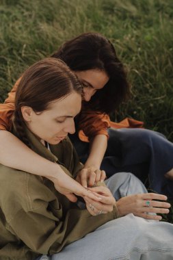 Ormanda tatilin tadını çıkaran iki mutlu beyaz kadın. Neslin neşeli güzel kızları cep telefonuyla fotoğraf çektirmek için poz veriyor. Güçlü bir kadın arkadaşlığı. Dizinin bir parçası.