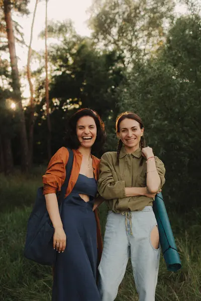 stock image Two happy young Caucasian women enjoying vacation in the forest. Cheerful beautiful girls of generation z pose for photo with mobile phone. Strong female friendship. Part of the series.