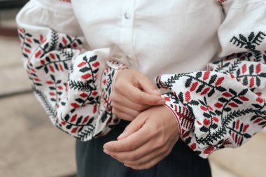 Kırmızı ve siyah iplikli kadın ellerinin yakın çekimi, mesaj için boşluk. Ukrayna ulusal kıyafetleri. Dizinin bir parçası.