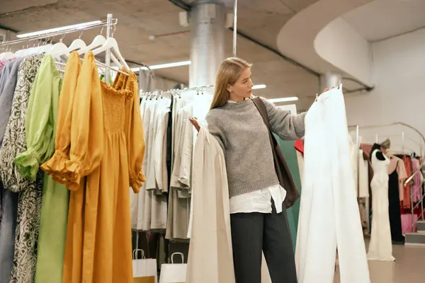 stock image Middle aged woman choosing clothes in a clothing store. Sale promotion and shopping concept. Part of the series.