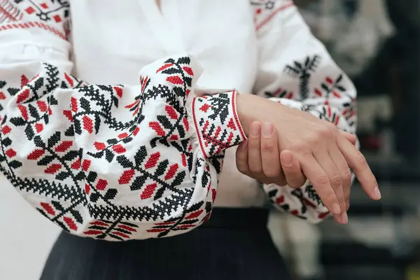 stock image Close-up of female hands in shirt with red and black thread, space for text. Ukrainian national clothes. Part of the series.