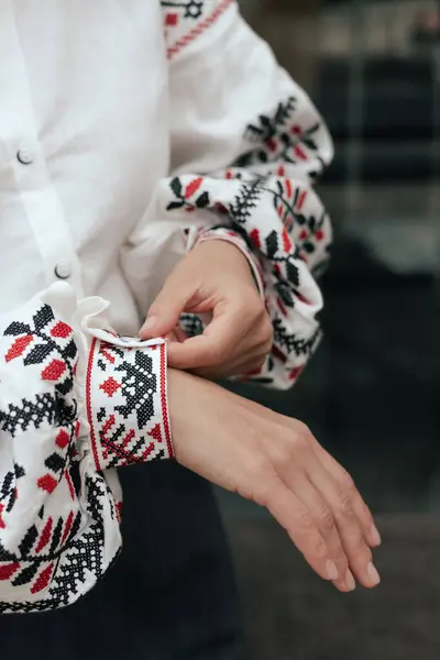 stock image Close-up of female hands in shirt with red and black thread, space for text. Ukrainian national clothes. Part of the series.