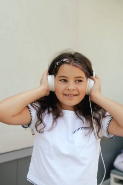 Mutlu funky gen Alpha kızı en sevdiği müziği kulaklıkla duyar ve onunla dans eder. Bir serinin parçası.