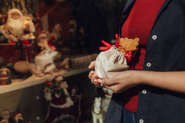 Hediyelik eşya dükkanının arka planında kırmızı kurdele olan kadın ellerini kapat. Tatil alışverişi kavramı. Bir serinin parçası.