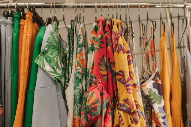 Perakende mağazasında farklı renklerde moda kıyafetleri seçiyor. Geri Dönüşüm Konseptini Azalt. Yatay fotoğraf.