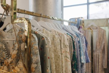 Perakende mağazasında farklı renklerde moda kıyafetleri seçiyor. Geri Dönüşüm Konseptini Azalt. Yatay fotoğraf.