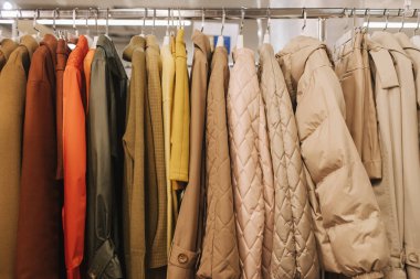 Perakende mağazasında farklı renklerde moda kıyafetleri seçiyor. Geri Dönüşüm Konseptini Azalt. Yatay fotoğraf.