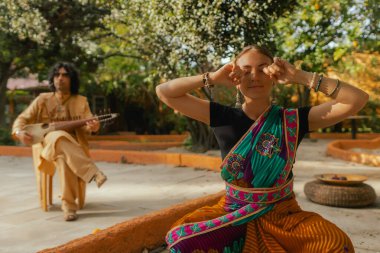 Geleneksel giysiler içinde Hint müzisyen dışarıda sitar festivali sezonu oynuyor. Geleneksel sari dansında gülümseyen ve festivalin tadını çıkaran genç bir kadın. Mutlu Diwali karşılama fotoğrafları. Bir serinin parçası.