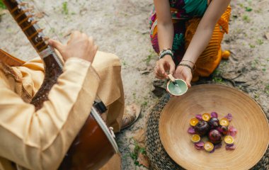 Indian musician in traditional clothes playing sitar festive season outdoor home. Woman in traditional saree hand lighting Diya lamp during Diwali festival. Happy greeting photo. Part of a series. clipart