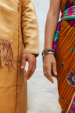 Close-up of Newlyweds couple hands at Indian wedding ceremony outdoors. Happy Diwali greeting photo. Part of a series. clipart