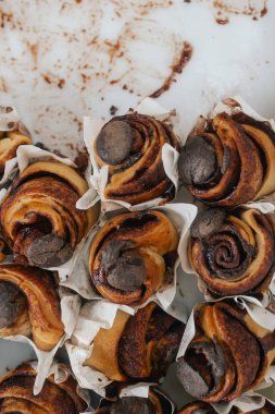 Rulo tarçın veya cinnabon, kopya alanı beyaz ahşap arka plan üzerinde beyaz krema soslu ev yapımı tatlı geleneksel tatlı çörekler.