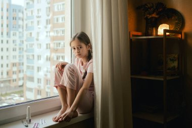 Hasta bir genç kız pencerenin yanında üzgün. Bir sürü kırmızı noktalı çocuk derisi. Alerjik reaksiyon, ilaç alerjisi, kızamık, deri iltihabı, bebek bezi döküntüsü, urtikya, uyuz, isilik. Bir serinin parçası.