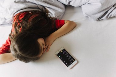 Yatakta yorganın altında yatan güzel bir genç kız. Sabah erken kalkmak, yatılı okul. Alarm onu uyandırıyor. Yeni nesil alfa ve yeni gün konsepti. Bir serinin parçası