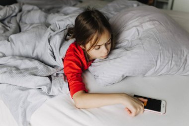 Yatakta yorganın altında yatan güzel bir genç kız. Sabah erken kalkmak, yatılı okul. Alarm onu uyandırıyor. Yeni nesil alfa ve yeni gün konsepti. Bir serinin parçası