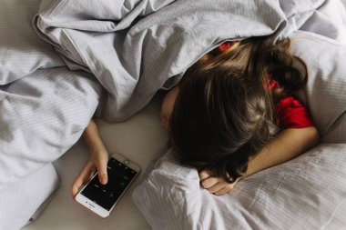 Yatakta yorganın altında yatan güzel bir genç kız. Sabah erken kalkmak, yatılı okul. Alarm onu uyandırıyor. Yeni nesil alfa ve yeni gün konsepti. Bir serinin parçası