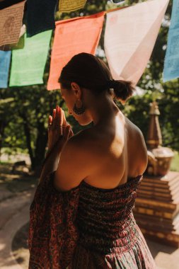 Bir Budist tapınağında yoga ve meditasyon yapan bir kadın, kapalı gözlerle rahatlamış. Dikkatli meditasyon konsepti. Sağlıklı olmak. Odak bulanıklığı ve gürültü etkisi yok. Dizinin bir parçası.