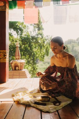 Bir Budist tapınağında yoga ve meditasyon yapan bir kadın, kapalı gözlerle rahatlamış. Dikkatli meditasyon konsepti. Sağlıklı olmak. Odak bulanıklığı ve gürültü etkisi yok. Dizinin bir parçası.