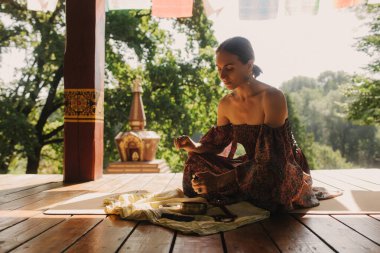 Bir Budist tapınağında yoga ve meditasyon yapan bir kadın, kapalı gözlerle rahatlamış. Dikkatli meditasyon konsepti. Sağlıklı olmak. Odak bulanıklığı ve gürültü etkisi yok. Dizinin bir parçası.