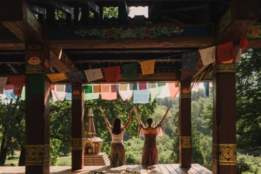 Düşünceli meditasyon ve çardakta yoga yapmadan önce kadın akıl hocası ve öğrenciyi kapatın. Meditasyon deneyimini kolaylaştırmak. Dizinin bir parçası. Tibet şarkı kasesi. Yumuşak odak, bulanık, gürültü efekti