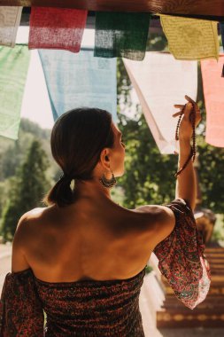 Bir Budist tapınağında yoga ve meditasyon yapan bir kadın, kapalı gözlerle rahatlamış. Dikkatli meditasyon konsepti. Sağlıklı olmak. Odak bulanıklığı ve gürültü etkisi yok. Dizinin bir parçası.