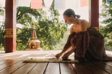 Bir Budist tapınağında yoga ve meditasyon yapan bir kadın, kapalı gözlerle rahatlamış. Dikkatli meditasyon konsepti. Sağlıklı olmak. Odak bulanıklığı ve gürültü etkisi yok. Dizinin bir parçası.
