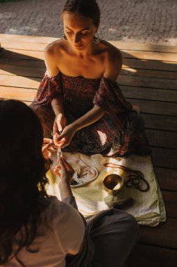 Düşünceli meditasyon ve çardakta yoga yapmadan önce kadın akıl hocası ve öğrenciyi kapatın. Meditasyon deneyimini kolaylaştırmak. Dizinin bir parçası. Tibet şarkı kasesi. Yumuşak odak, bulanık, gürültü efekti