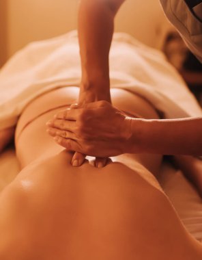 Masaj masasında yatan genç bir kadının omuzlarına masaj yapan kadın masörlerin elleri. Fizik tedavi konsepti, boyun basınç noktası. Dizinin bir parçası. Yumuşak odaklı, bulanık