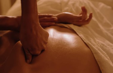 Masaj masasında yatan genç bir kadının omuzlarına masaj yapan kadın masörlerin elleri. Fizik tedavi konsepti, boyun basınç noktası. Dizinin bir parçası. Yumuşak odaklı, bulanık