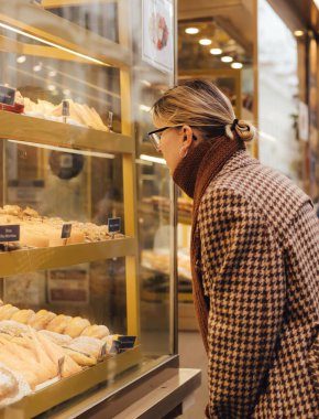 Lizbon 'daki bir fırının vitrininde Portekizli pastacı Pastel de Nata' yı arayan Z Gen orta yaşlı kadın. Yalnız turizm ve seyahat. Bir serinin parçası