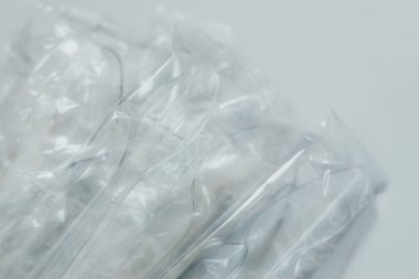 Plastik kaseleri ve kaşıkları hafif arka planda harcayın. Atık minimize etme, plastik geri dönüşüm endüstrisi ve tüketim kavramı. Metin için yer alan arkaplan, Üst Görünüm. Bir serinin parçası