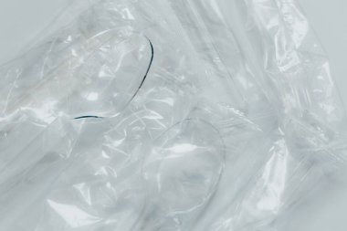 Plastik kaseleri ve kaşıkları hafif arka planda harcayın. Atık minimize etme, plastik geri dönüşüm endüstrisi ve tüketim kavramı. Metin için yer alan arkaplan, Üst Görünüm. Bir serinin parçası