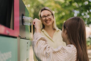 Annem Alfa Güzeli 'ne atık kutularının yakınındaki çöpleri ayırmayı öğretiyor. Plastik, kağıt, cam, e-atık torbasını tekrar kullanılmak üzere kovaya atıyorum. İklim değişikliğine yardım ve temiz çevre yeşili kavramı israf değil