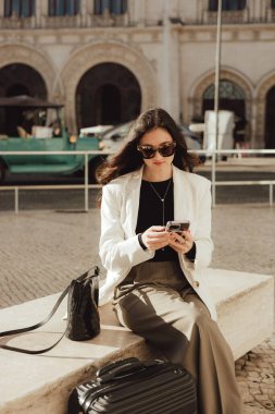 Lizbon 'daki tren istasyonunda bavullu bir Vlogger yolcusu telefon kullanıyor. İş seyahati ve yalnız turizm konsepti. Zombi Kız Etkilenen Sokakta Sosyal medya hikayeleri çekiyor. Dizinin bir parçası
