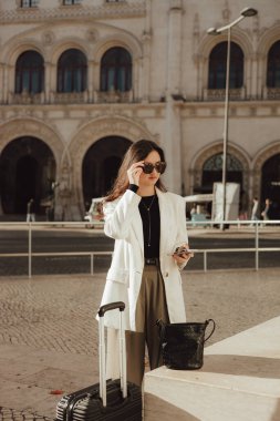 Lizbon 'daki tren istasyonunda bavullu bir Vlogger yolcusu telefon kullanıyor. İş seyahati ve yalnız turizm konsepti. Zombi Kız Etkilenen Sokakta Sosyal medya hikayeleri çekiyor. Dizinin bir parçası