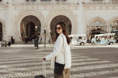 Lizbon 'daki tren istasyonunda bavullu bir Vlogger yolcusu telefon kullanıyor. İş seyahati ve yalnız turizm konsepti. Zombi Kız Etkilenen Sokakta Sosyal medya hikayeleri çekiyor. Dizinin bir parçası