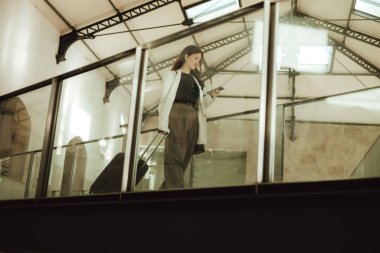 Lizbon 'daki tren istasyonunda bavullu bir Vlogger yolcusu telefon kullanıyor. İş seyahati ve yalnız turizm konsepti. Zombi Kız Etkilenen Sokakta Sosyal medya hikayeleri çekiyor. Dizinin bir parçası