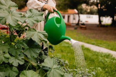 Bahçedeki eko-çiftlikte çiçeklerle ve bitkilerle ilgilenen çiçekçi olarak bahçe aletleriyle kadınların bacaklarına yakın çekim. Yeşil turizm kavramı, yavaş yaşam, bahçıvanlık, çevre dostu. Dizinin bir parçası